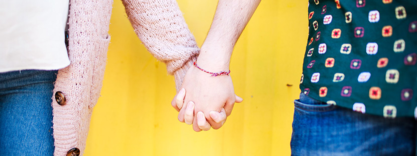 a couple holding hands on gorleston beach during an inlove photoshoot