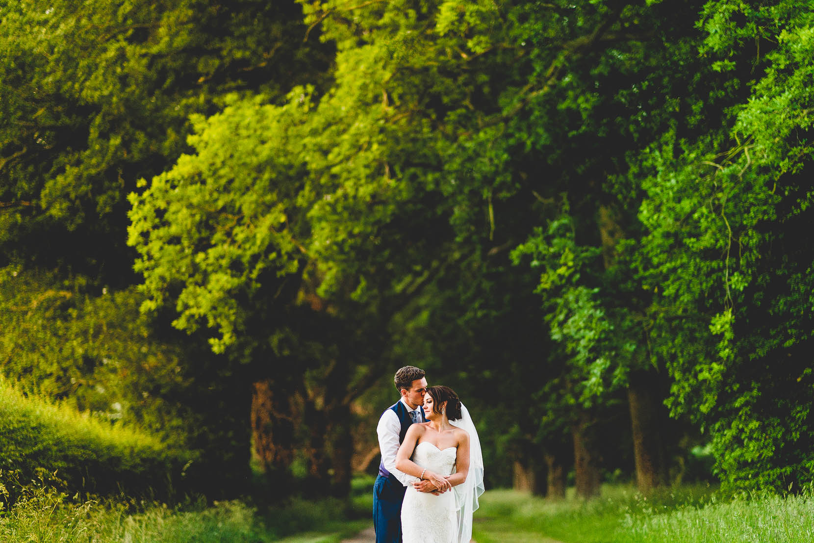 wedding photograph of daniel and melissa having a snuggle at woodhall manor in suffolk