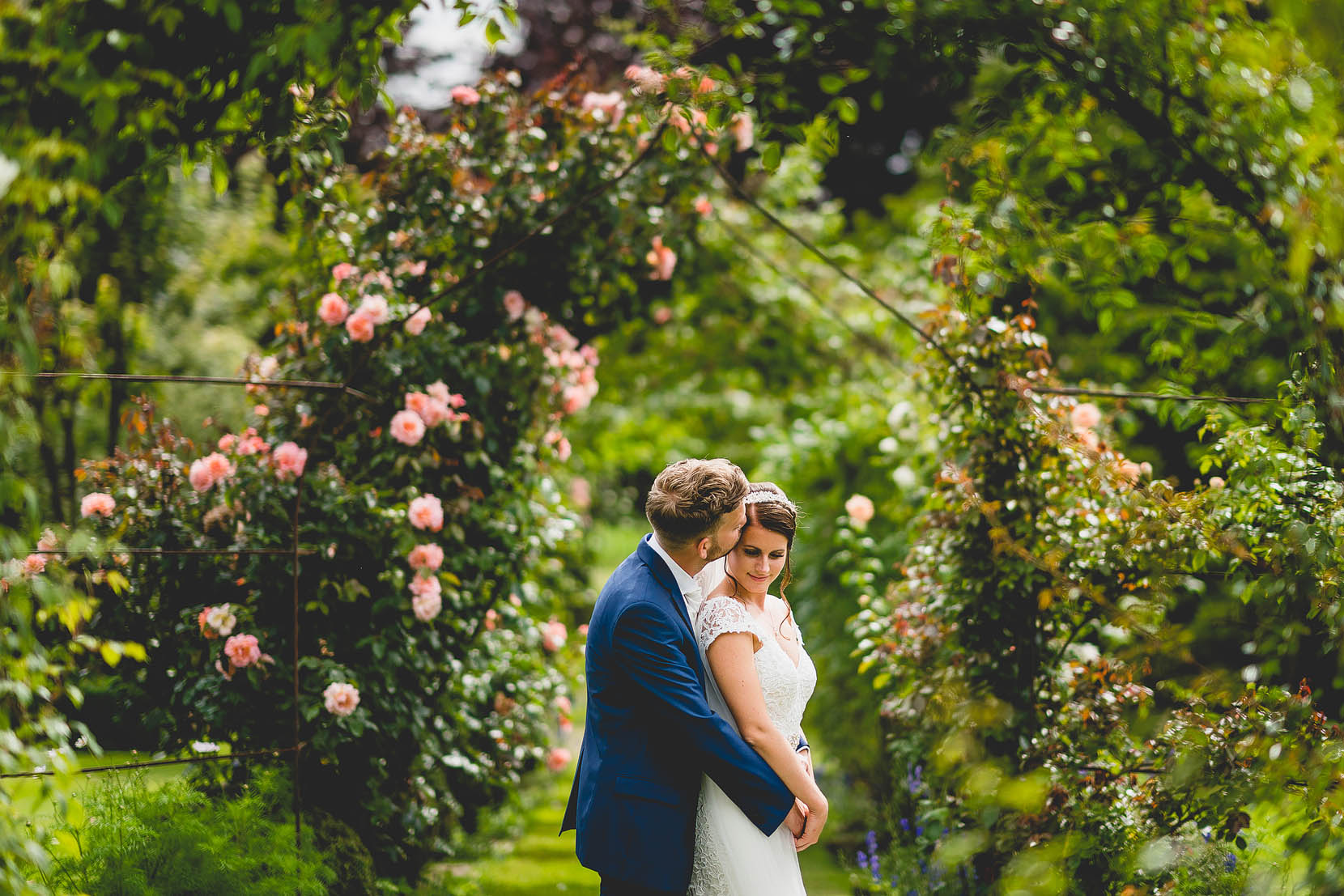 Norfolk Wedding at Elms barn with Jess and Adam having a cuddle in the rose arch