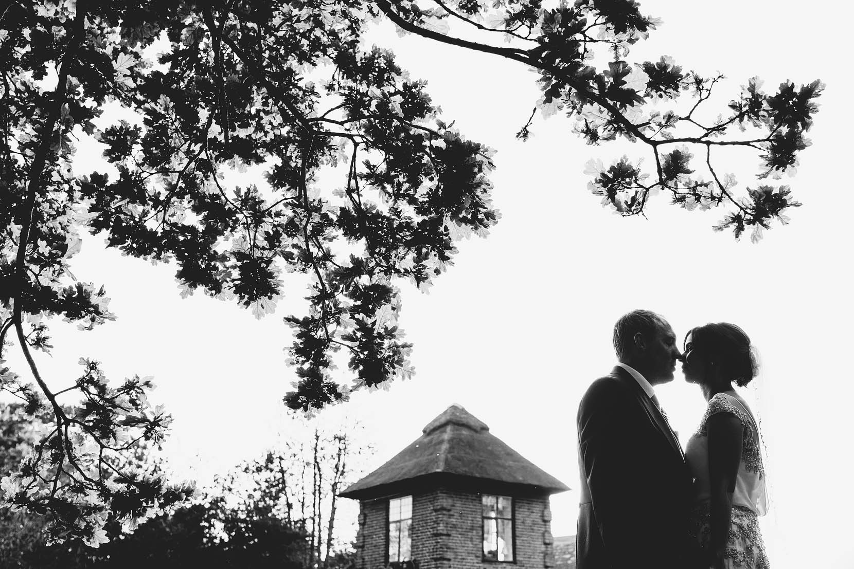 tom and kate have a kiss under the oak tree at southwood hall