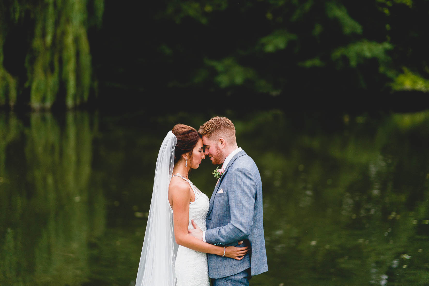 dunston hall wedding photography over the back lake during golden hour with michael and rebecca