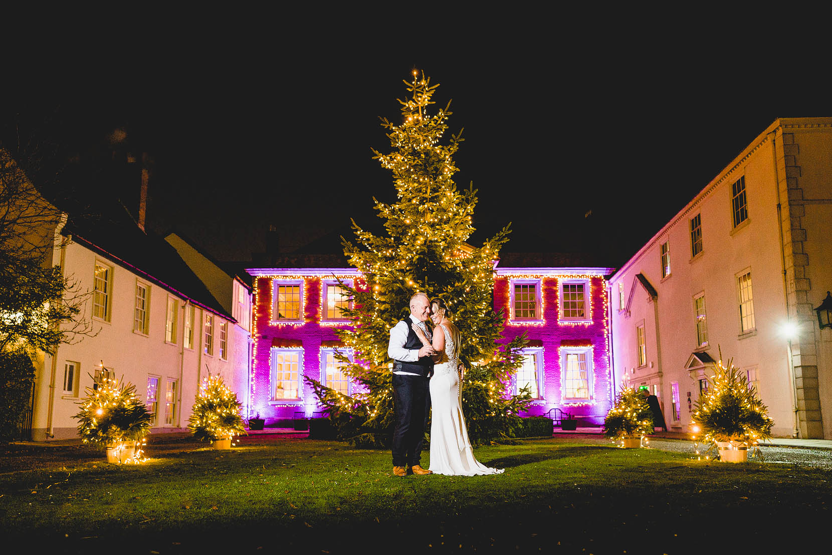 Victoria and Jeremy having a kiss in front of the Christmas tree at their Assembly House Wedding